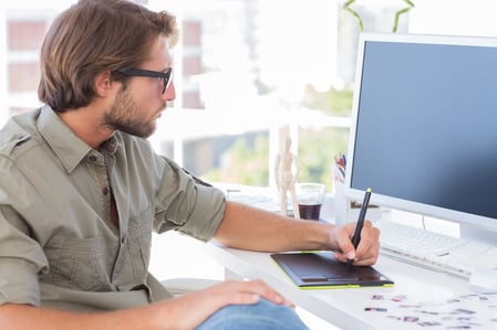 Artist using graphics tablets sitting at desk