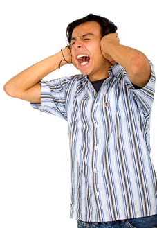 casual annoyed man screaming and covering his ears because he cant stand the noise - isolated over a white background